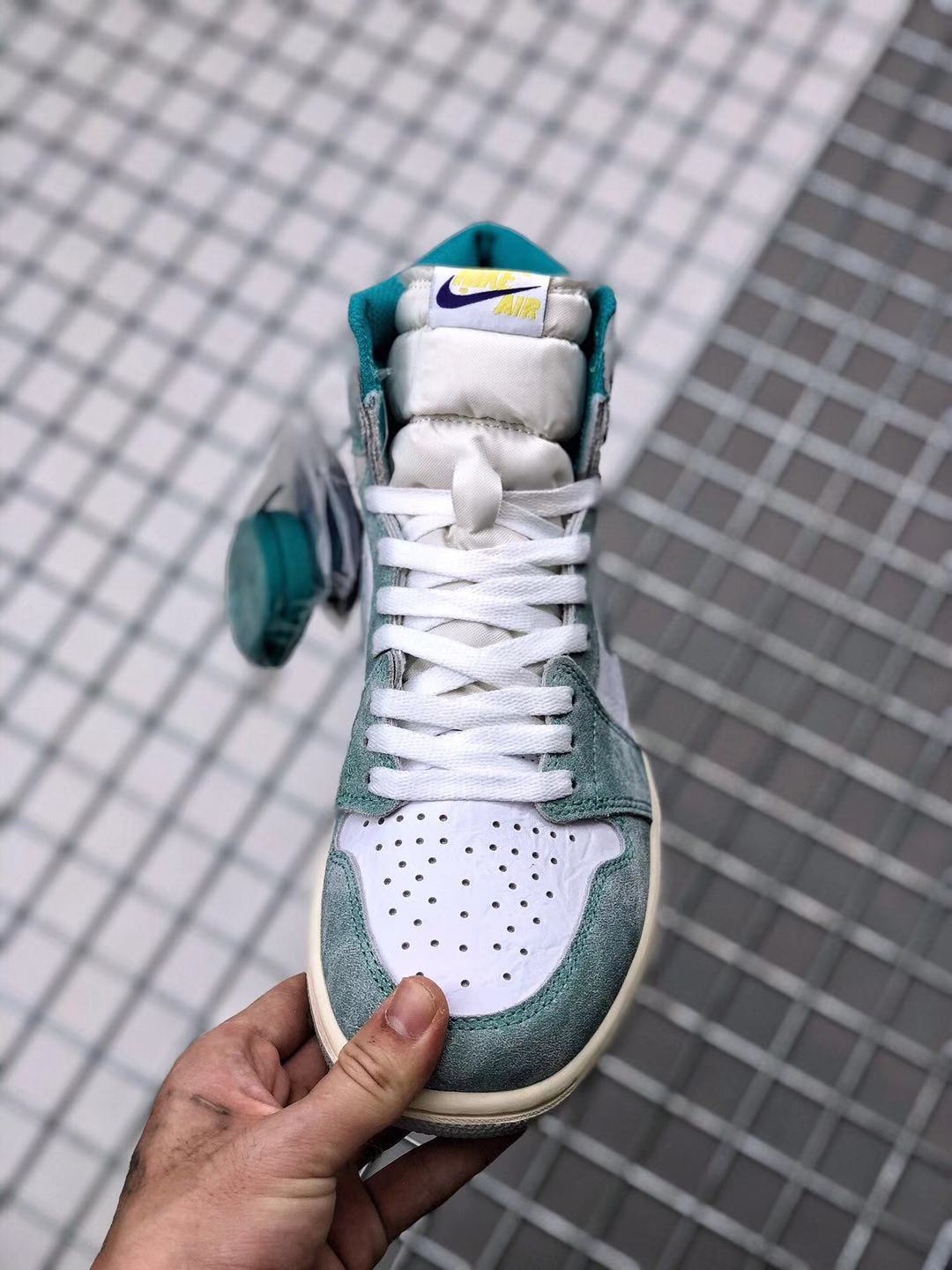 Front view of the high-top sneaker showing the padded tongue, white laces, perforated white toe box, and teal-green trim.