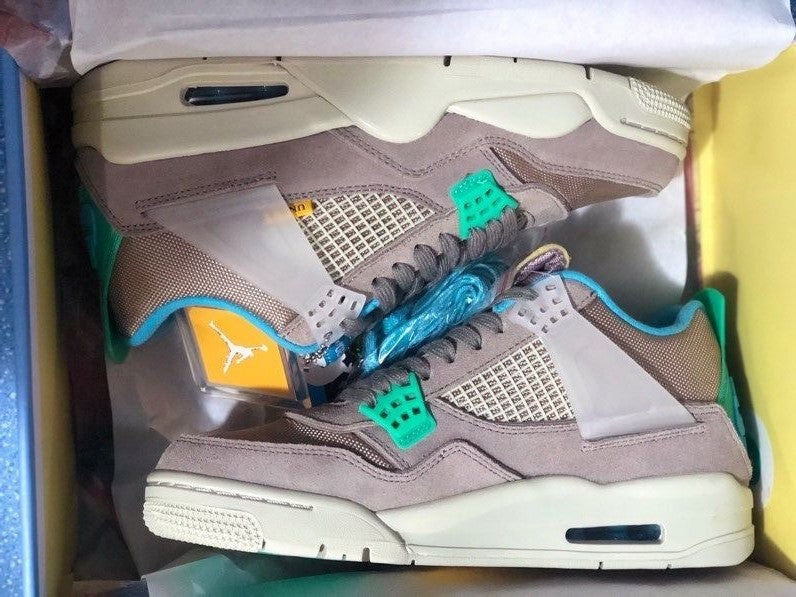 Pair of sneakers inside the box with tissue paper, blue spare laces, and the photographed packaging accessories.