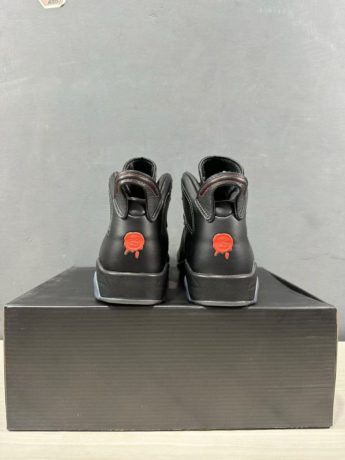 Rear view showing the padded collars and red heel graphics on the black sneakers.