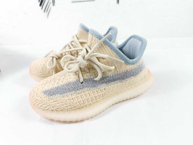 Pair of linen-yellow sneakers with gray side stripes, matching laces, and translucent soles.