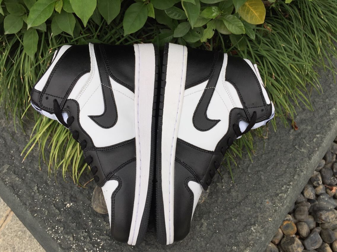 Top-down side view of the pair showing the contrasting black and white upper panels and white midsoles.