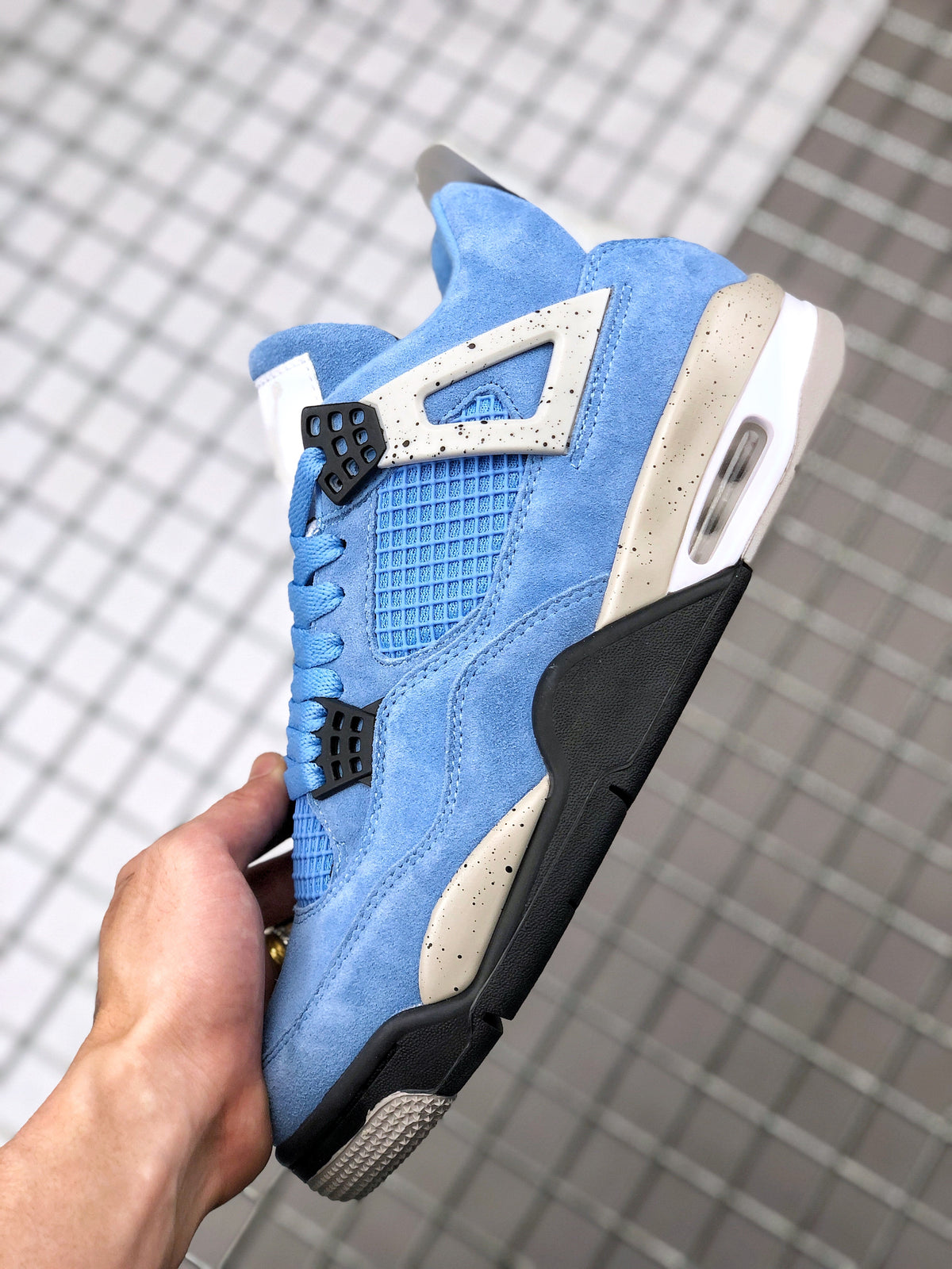 Side view highlighting the blue upper, speckled support panel, black lower section, and visible midsole window.