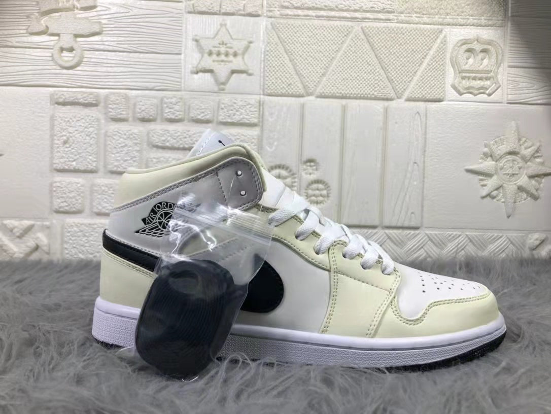 Side profile of a cream and white mid-top sneaker with black detailing and a clear bag containing an extra black lace accessory.