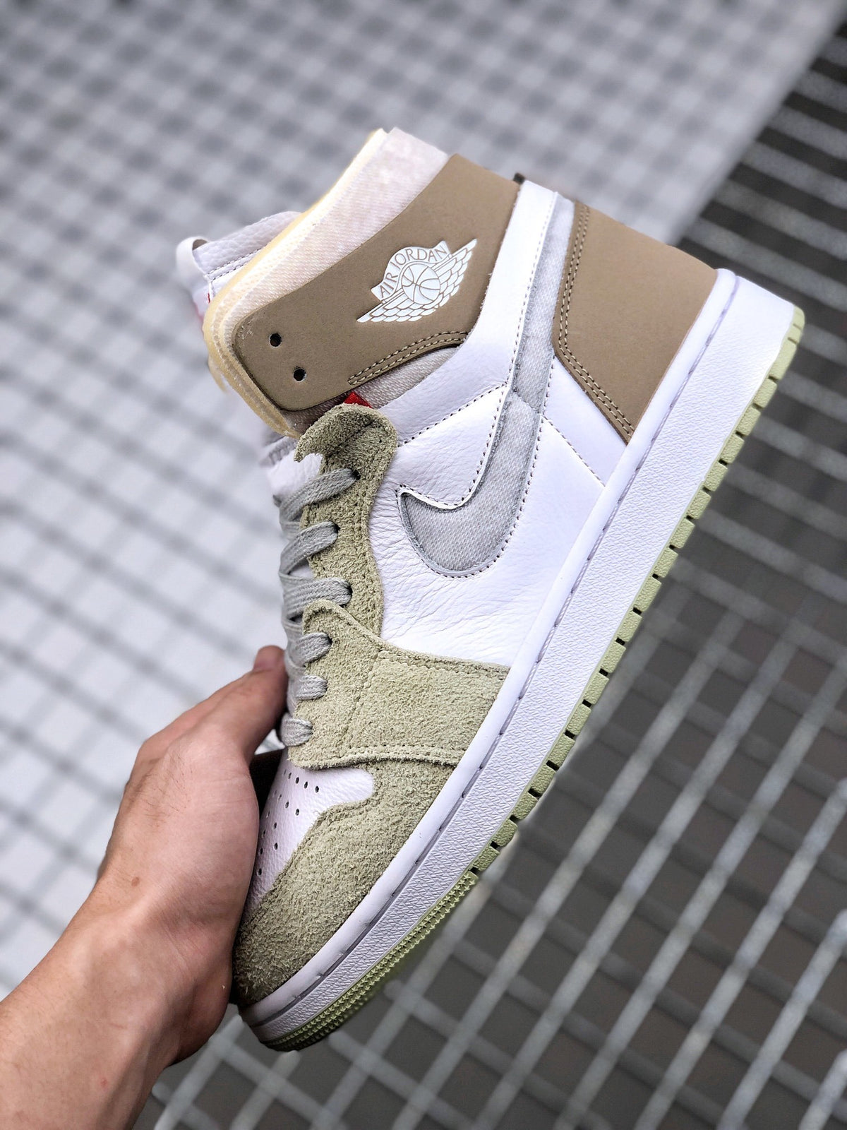 Side view of the sneaker showing the white upper, gray Swoosh, olive green overlays, brown ankle panel, and white midsole.