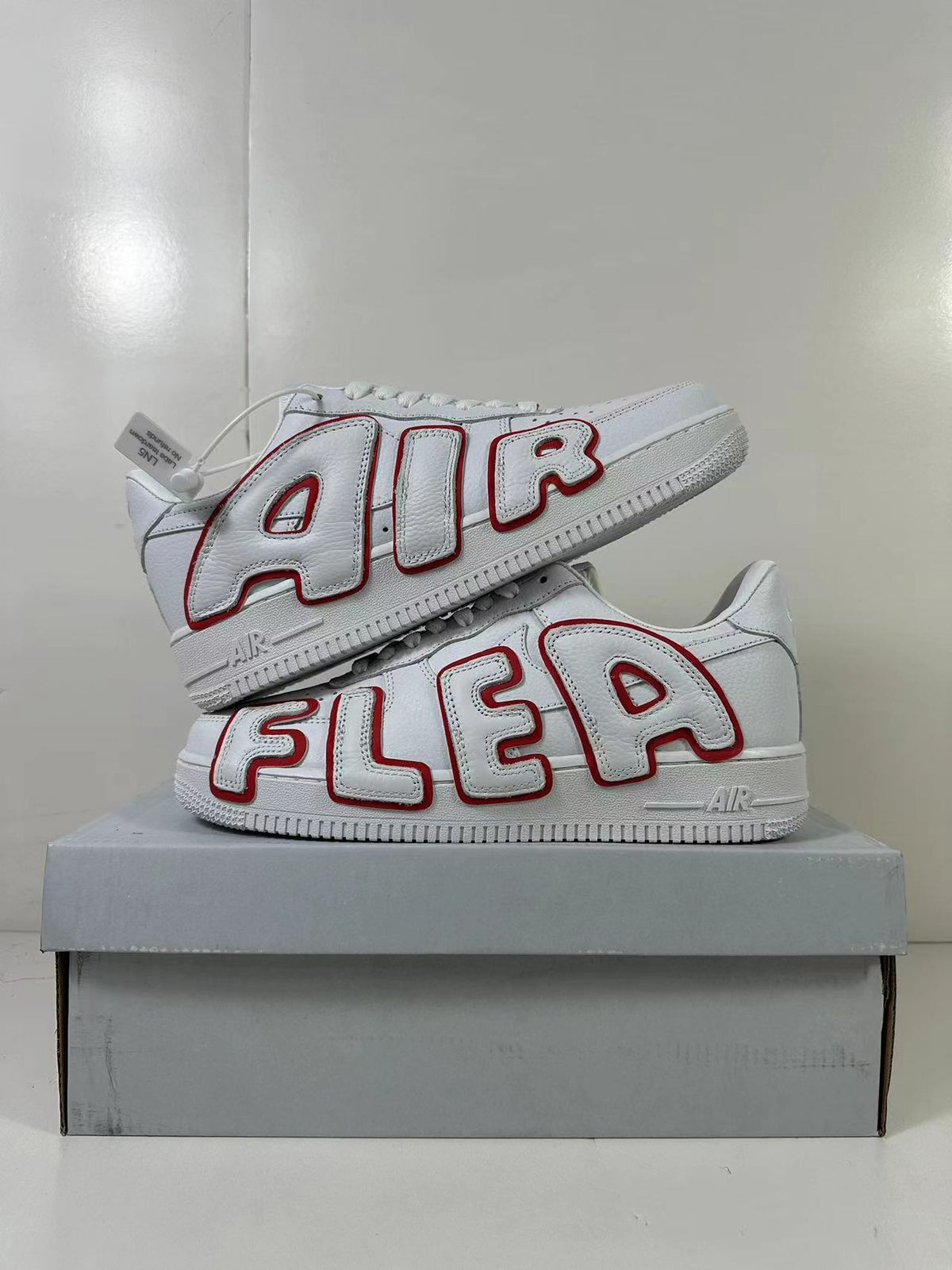 Stacked view of the pair showing the contrasting red-outlined AIR lettering and white low-top construction.