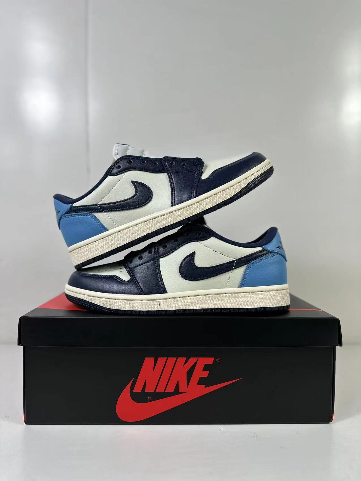 Two low-top sneakers displayed together on a Jordan shoebox, showing the side panels and rubber outsoles.