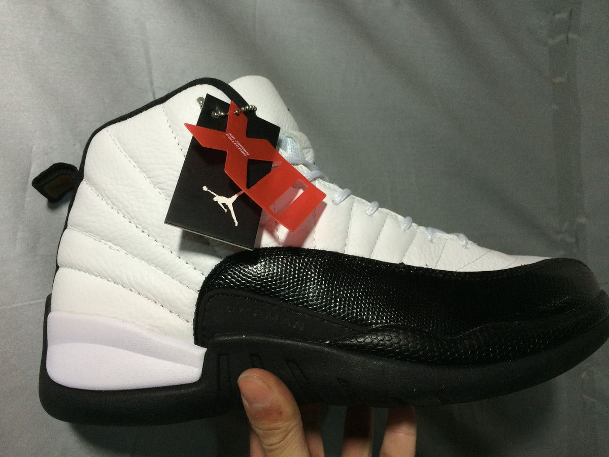 Hand-held side view showing the white and black high-top profile and attached hangtags.