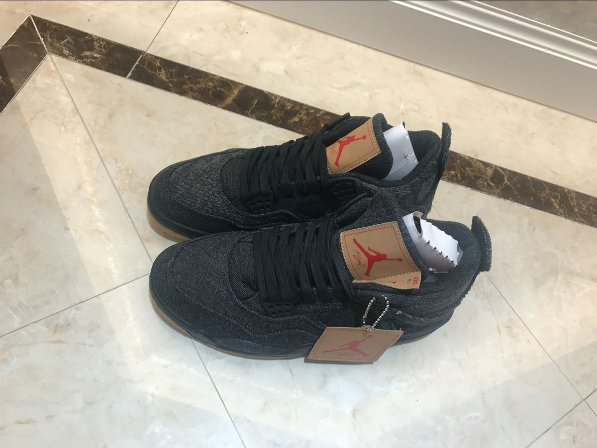Pair of black high-top sneakers shown from above on a tiled floor.