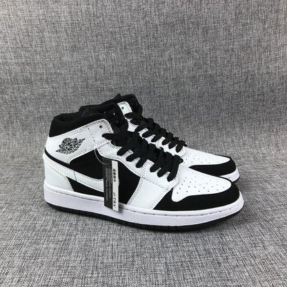 Pair of black-and-white high-top sneakers showing the ankle wings branding, black laces, and white midsoles.