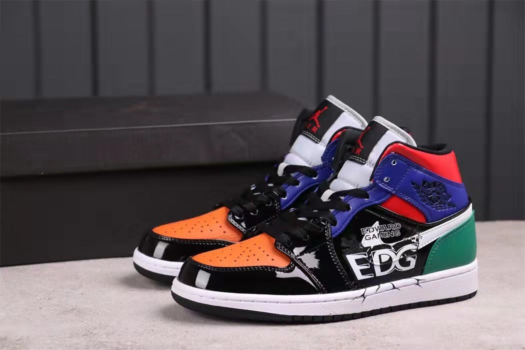 Pair of multicolor Jordan mid-top sneakers with orange toes, blue and red collars, green heel panels, and EDG side graphics.