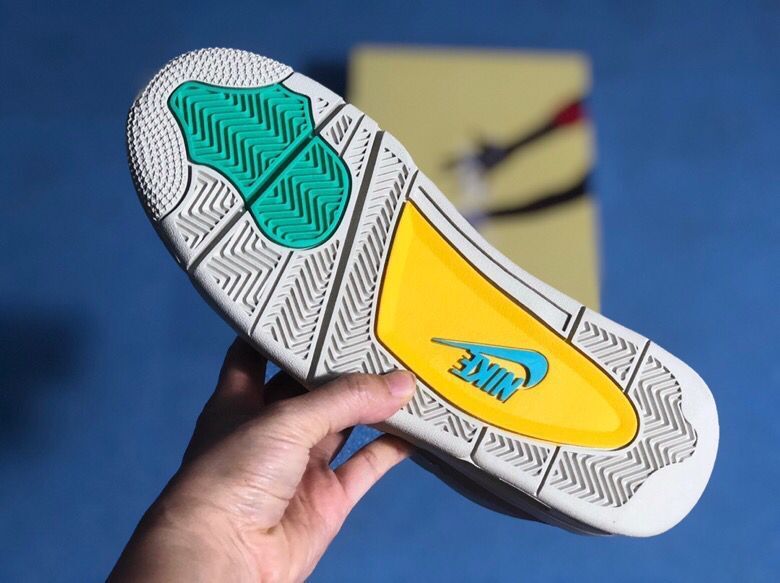Outsole view showing patterned traction, teal sections, and a yellow central panel.