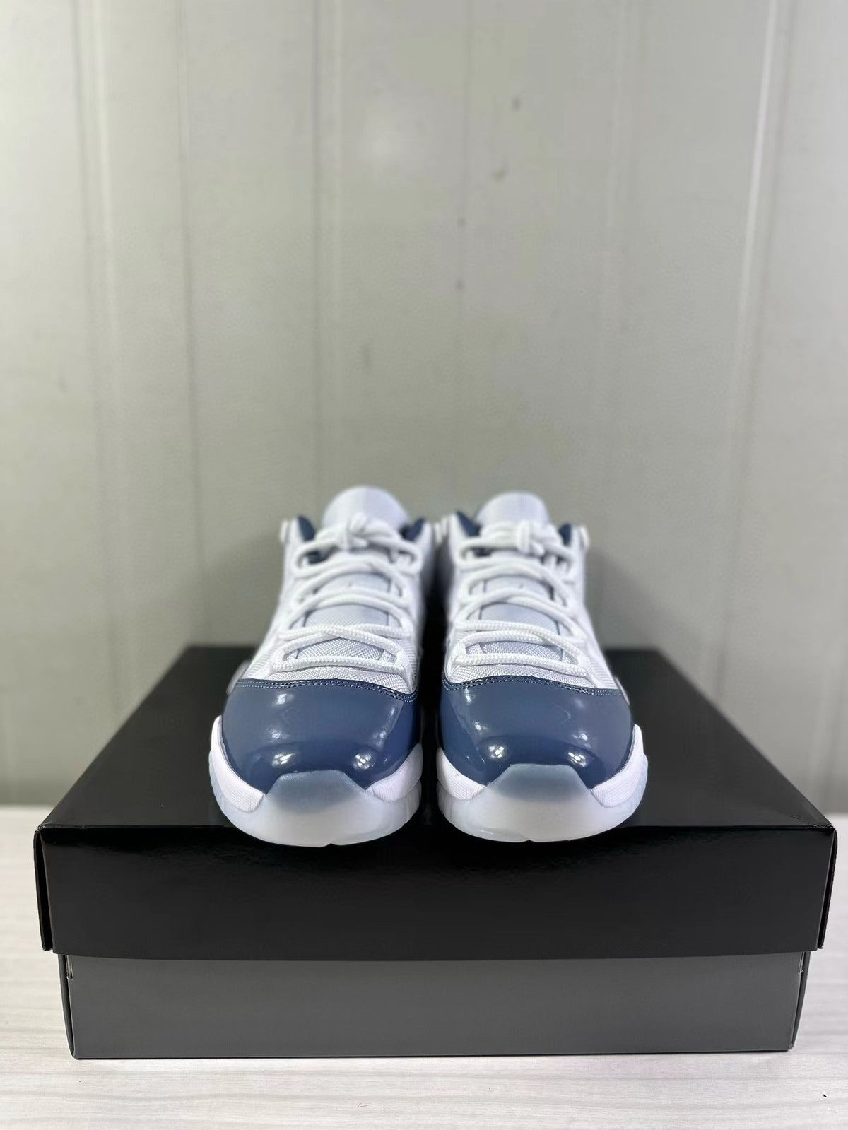 Front view of the pair of white and blue low-top sneakers