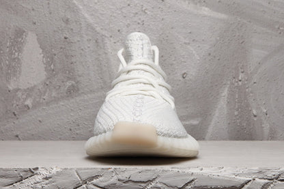 Front view of a white Yeezy 350 V2 sneaker with tonal laces and a rounded toe.