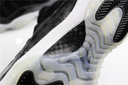 Close-up of the sneaker outsole showing a translucent midfoot section, black traction inserts, and textured black upper detailing.