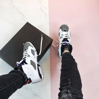 Pair of Air Jordan 6 Flint sneakers worn with a black Jordan shoebox in the background.