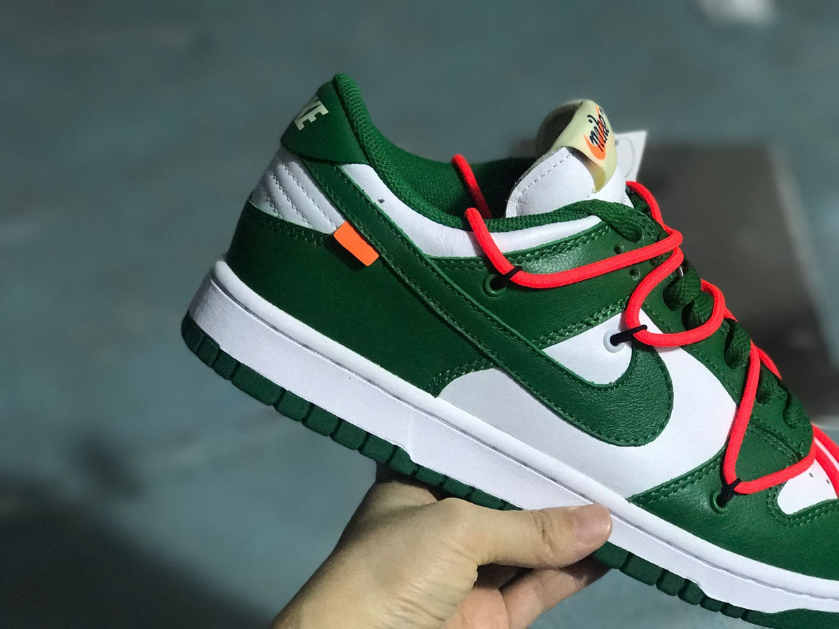 Angled heel-side view showing the layered green and white upper and orange accent tab.