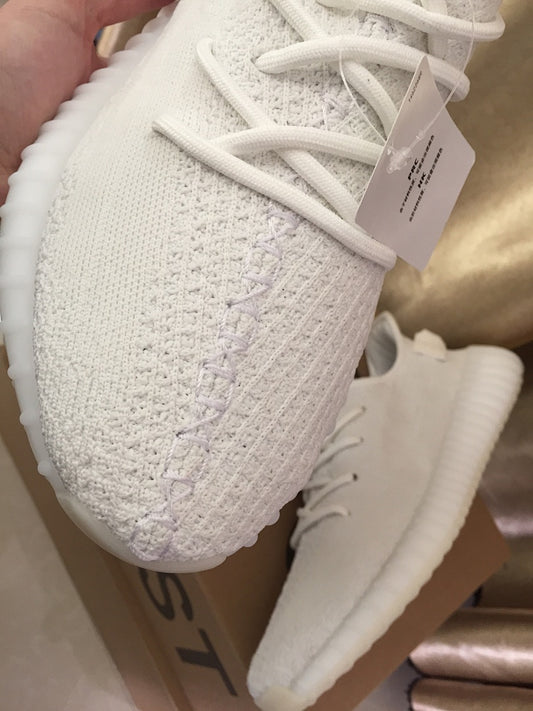 Close-up of the white knitted toe and matching laces, with the ribbed sole visible beneath.