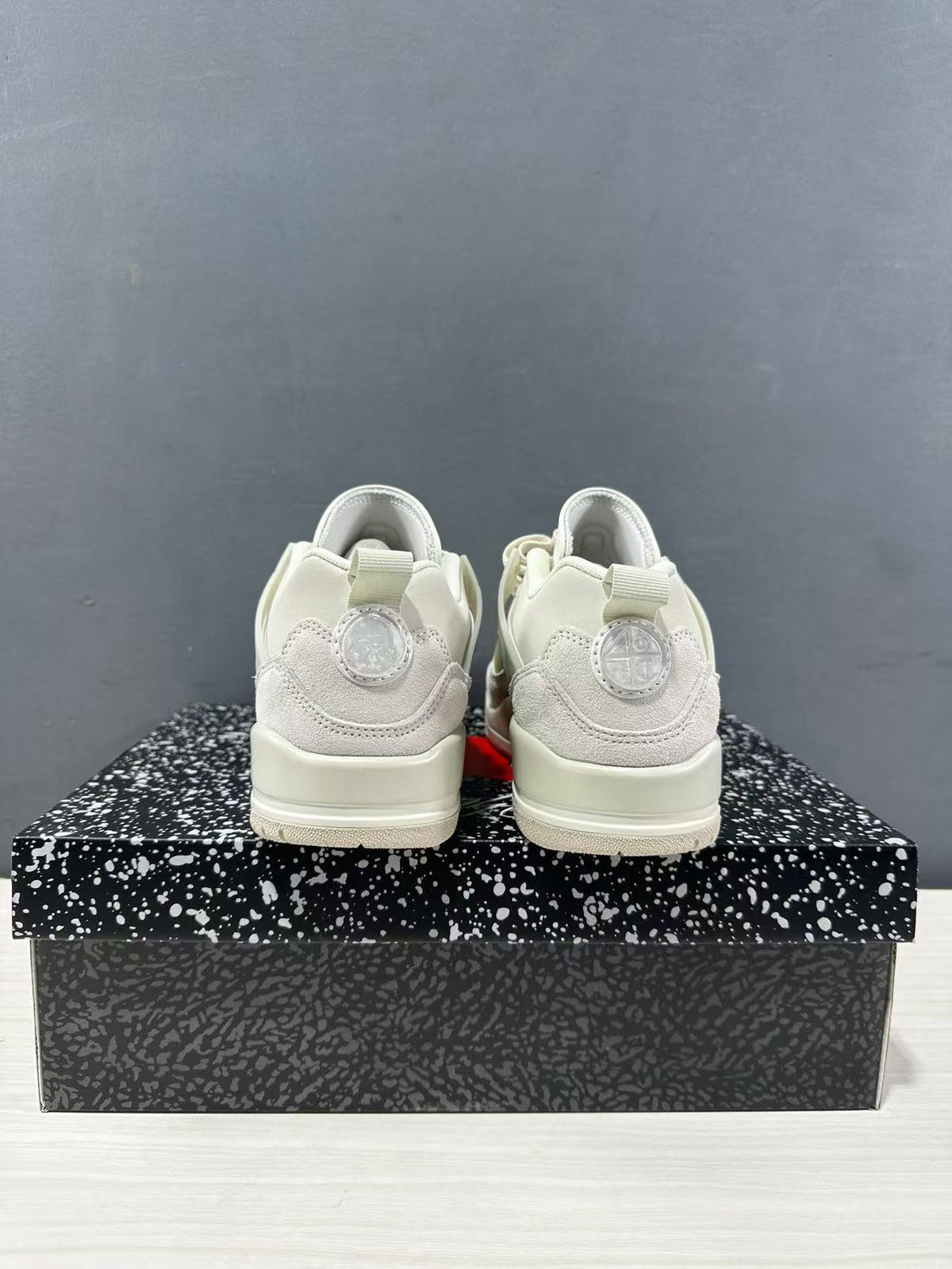 Rear view showing the heel panels, pull tabs, and circular heel details on the sneakers.