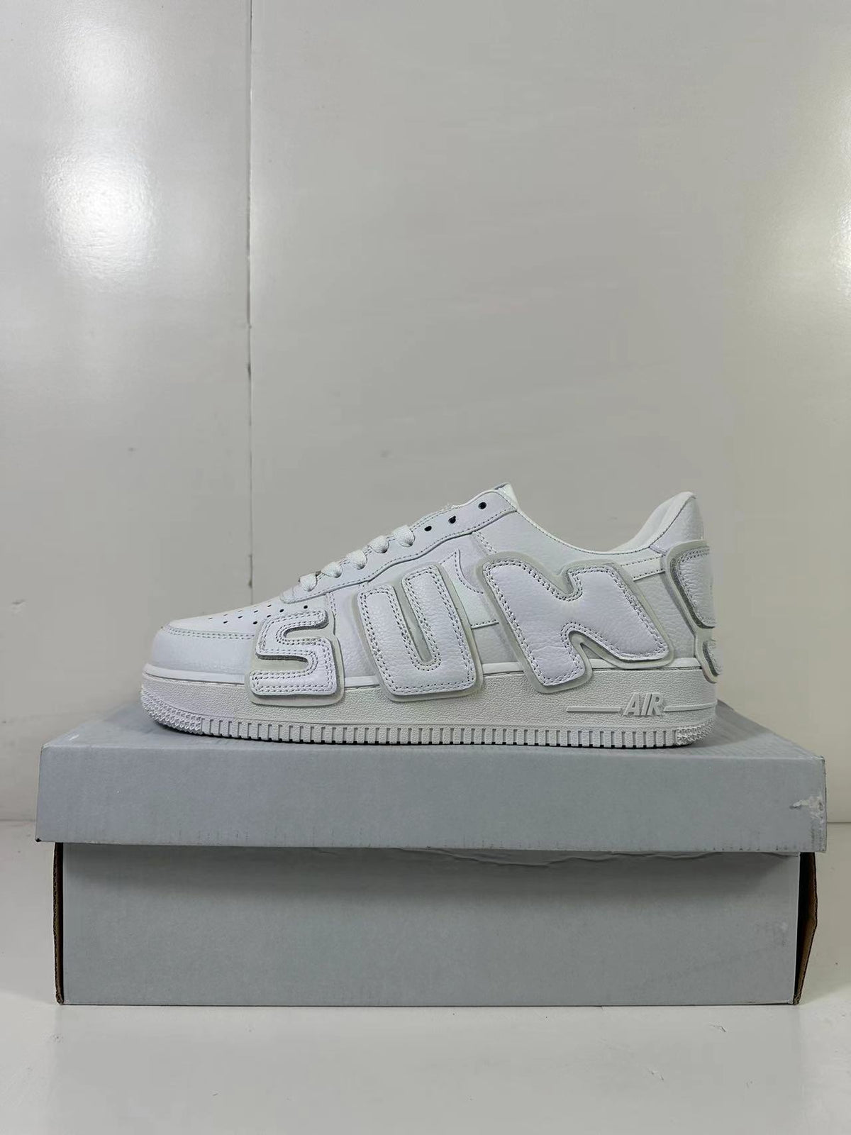 Side profile highlighting the oversized raised “SUN” lettering and white midsole.