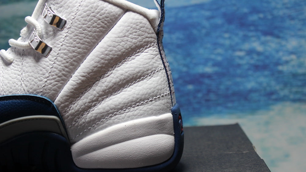 Side close-up of the white textured upper and navy heel and midsole details.