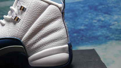 Side close-up of the white textured upper and navy heel and midsole details.
