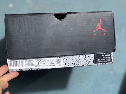 Black Jordan shoebox with a visible label identifying Air Jordan Retro 5 and EU size 42.