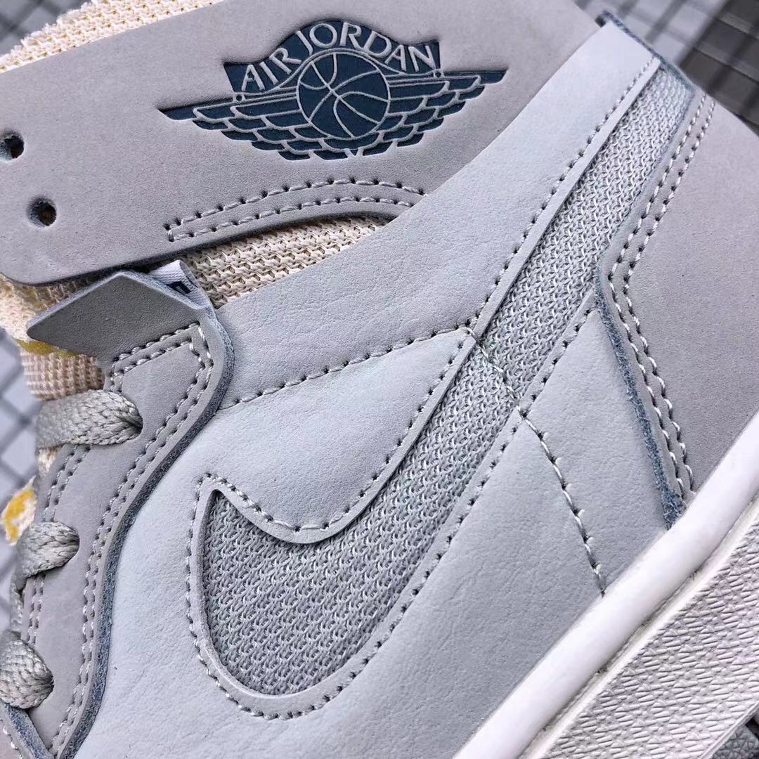 Close-up of the gray side panel, Swoosh, stitching, laces, and winged basketball branding.