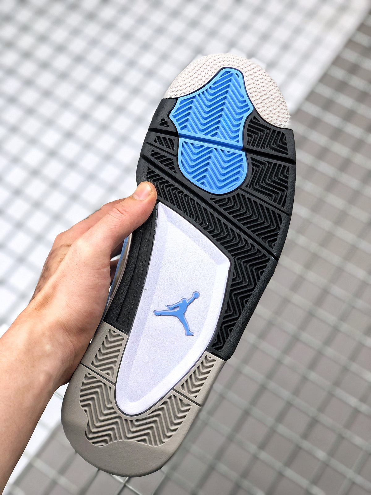 Outsole view showing black, blue, white, and light gray sections with a patterned tread.