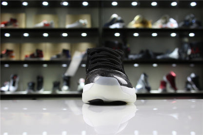 Front view of a single sneaker showing the rounded silver-black toe, black laces, and translucent outsole edge.