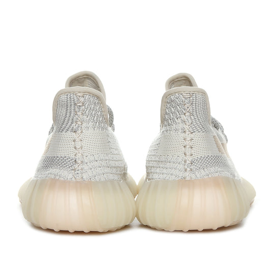 Rear view of a pair of cream and gray knit sneakers with translucent ribbed soles.