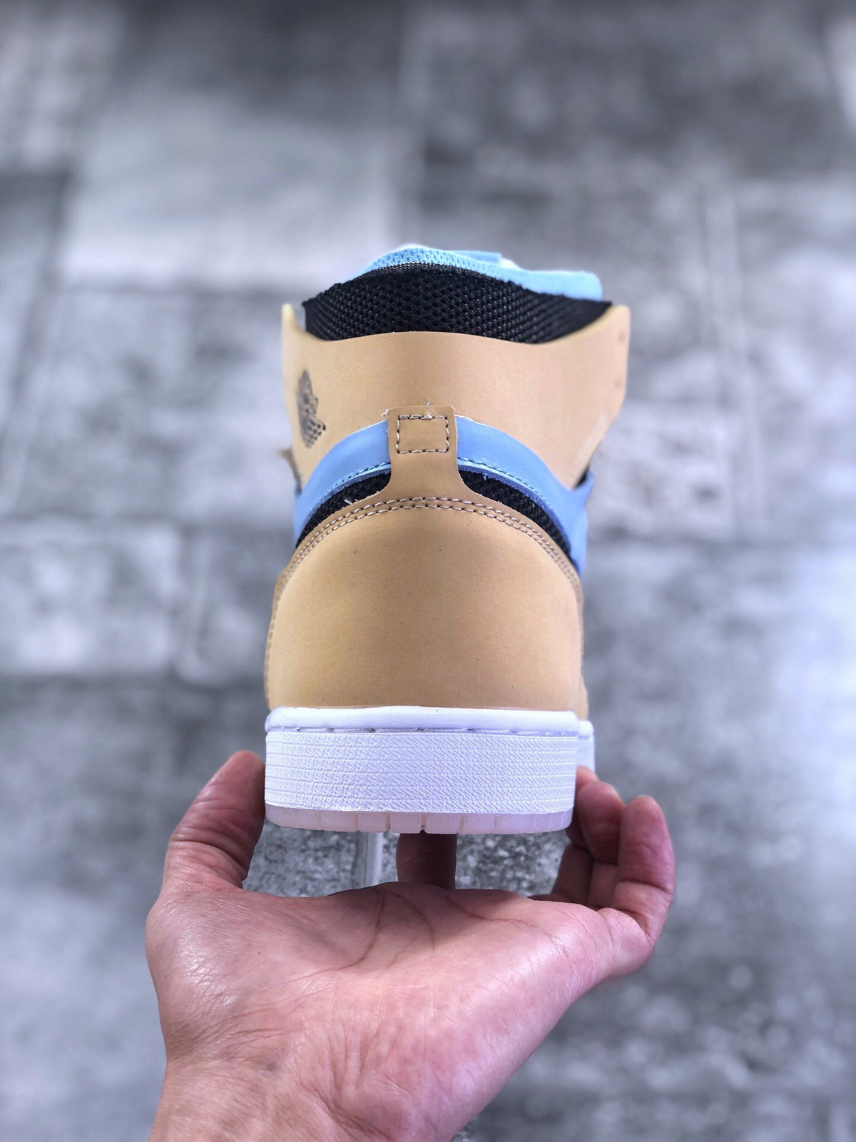 Rear view of the tan and light blue high-top sneaker showing the heel panel, collar, and white outsole.
