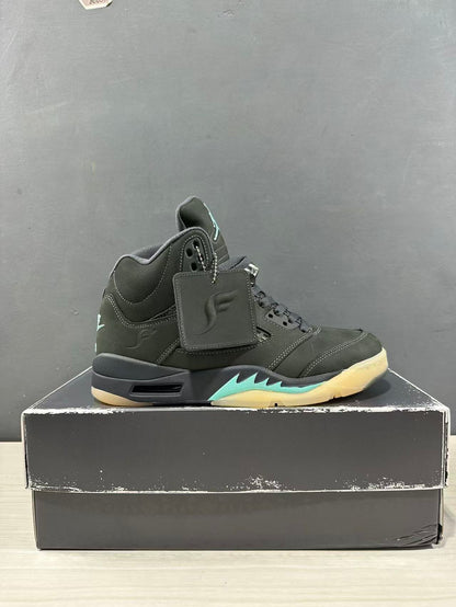 Side view of a dark green and black Jordan Air Jordan 5 sneaker with aqua midsole accents, displayed on a shoe box.