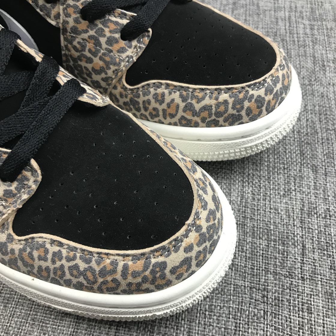 Close-up of the black perforated toe box bordered by leopard-print overlays.