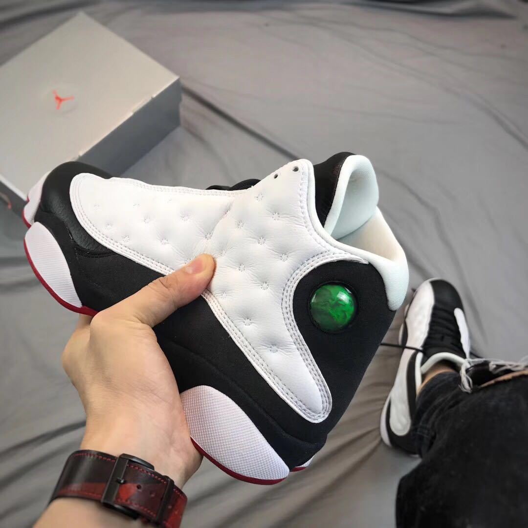 Close side view of the white textured panel, black heel area, circular detail, and segmented white outsole.