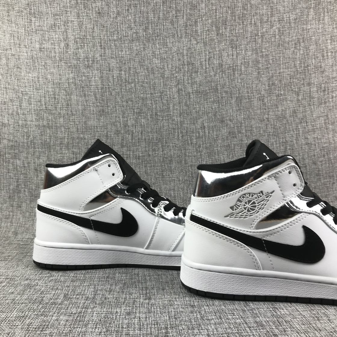 Two matching white, black, and metallic silver mid-top sneakers shown from the side.