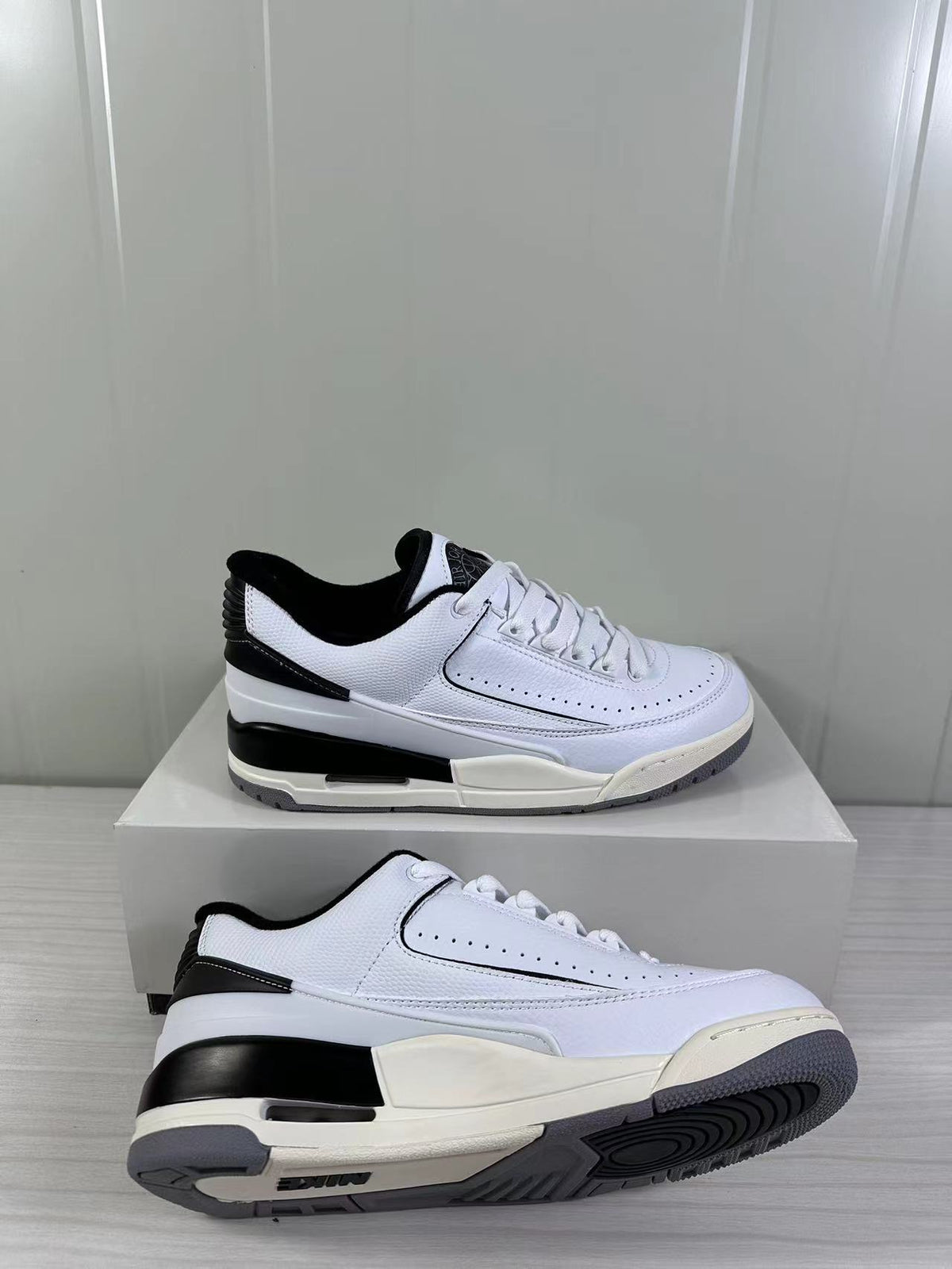 Angled side view showing the white upper, black heel accents, layered midsole, and gray outsole.