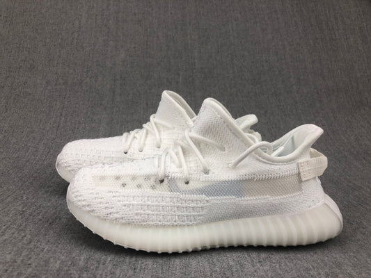 Pair of white knit-look kids sneakers shown from a side angle on a gray background.