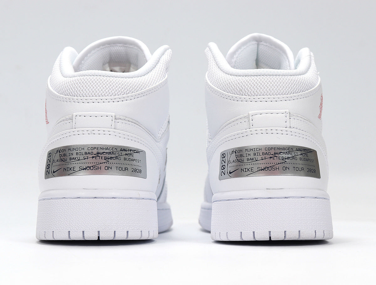 Rear view of the white sneakers showing padded collars and metallic heel labels with printed city text.