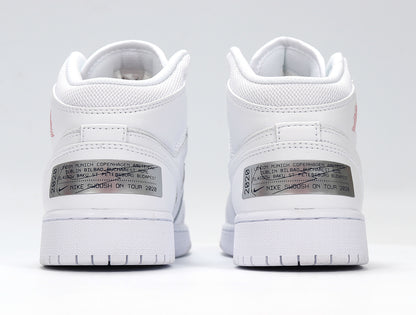 Rear view of the white sneakers showing padded collars and metallic heel labels with printed city text.