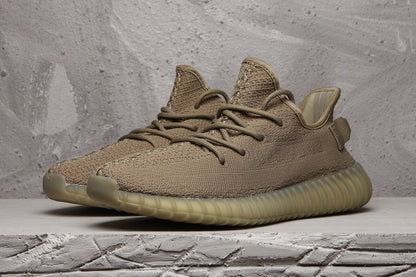 Front three-quarter view of a brown-tan low-top sneaker with matching laces and ribbed sole.