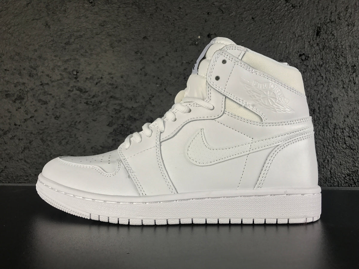 Side profile of the white high-top sneaker showing the Swoosh, Jordan Wings emblem and segmented outsole.