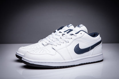 Front three-quarter view of a pair of white low-top Jordan sneakers with dark collar details.