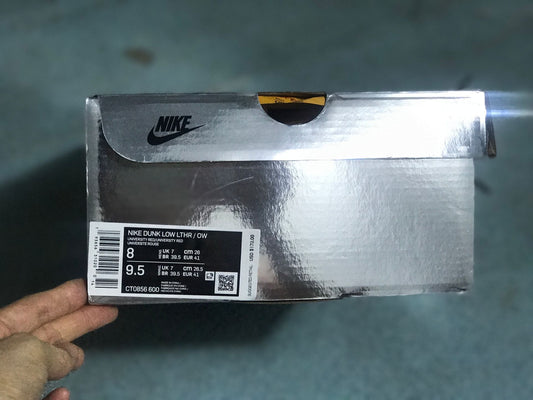 Nike shoe box showing the Dunk Low LTHR/OW label, style code CT0856 600, and sample sizing information.