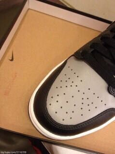 Close-up of the grey perforated toe box and black trim inside the shoebox.