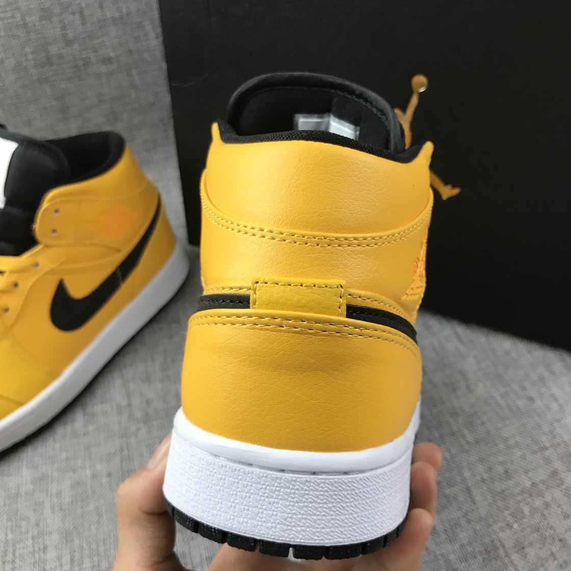 Rear view showing the yellow padded collar, black lining, and white midsole.