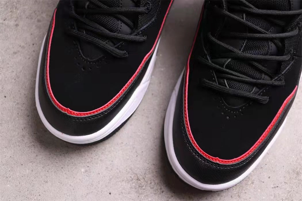 Close-up of the black toe boxes, black laces, and red edging.