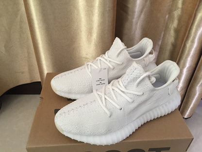 Pair of white knit sneakers displayed on a shoebox from a front three-quarter view.