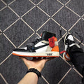 Side view emphasizing the black, white, and orange color blocking and printed midsole text.