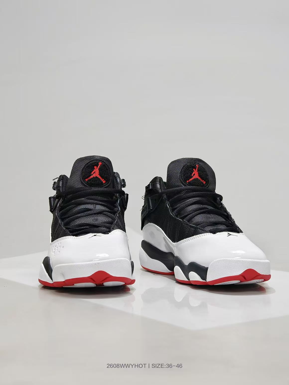 Front three-quarter view showing the white toe panels, black uppers, and red outsole accents.