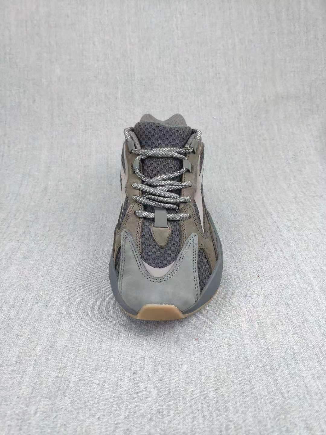 Top-down view of the gray sneaker showing the laces, tongue, toe box, and layered upper.